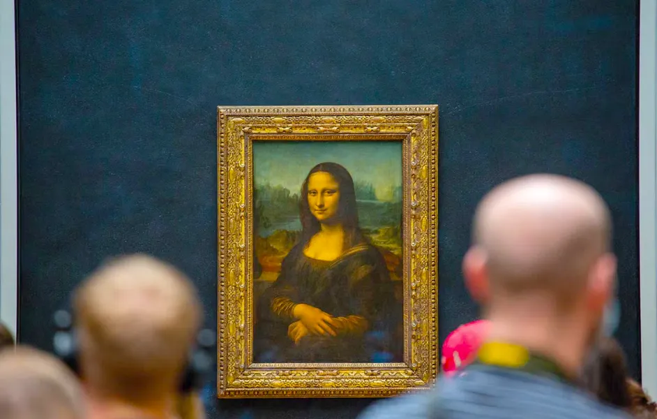 Mona Lisa painting at the Louvre with a crowd of visitors in front