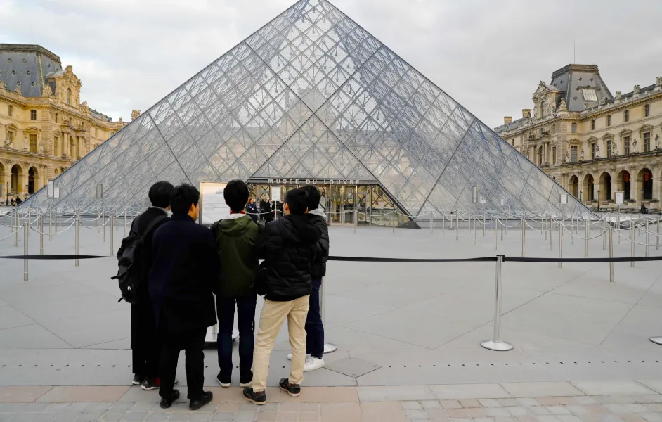 Tourist walking toward the Louvre Pyramid